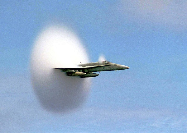 An F/A-18 Hornet creating a vapor cone at transonic speed just before reaching the speed of sound.